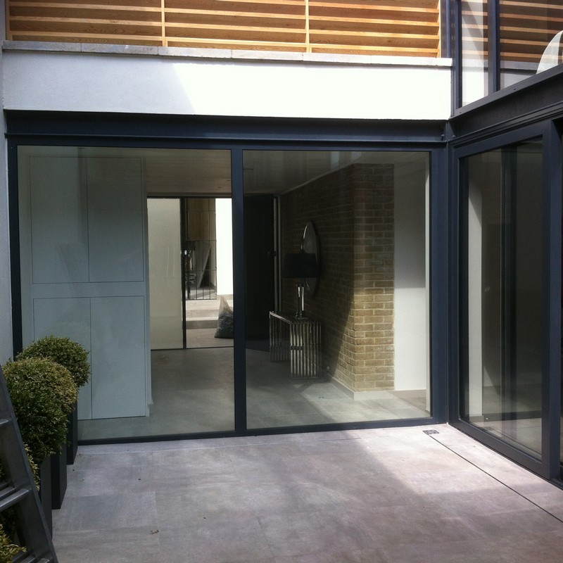 Floor-to-ceiling sliding doors opening to courtyard in Archway