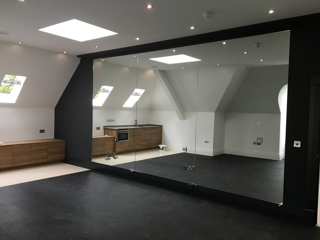 Frameless glass wall dividing loft conversion in Archway